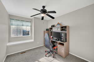 Home office featuring light colored carpet and a ceiling fan