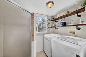 Laundry room featuring a wainscoted wall and washing machine and dryer