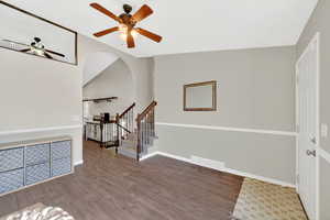 Foyer with dark wood-style floors, a ceiling fan, and lofted ceiling