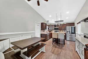 Dining room with light wood finished floors, ceiling fan, vaulted ceiling, and recessed lighting