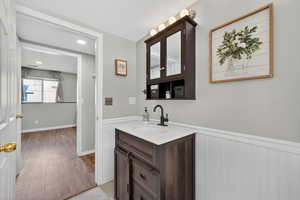 Bathroom with vanity, a wainscoted wall, recessed lighting, and light wood finished floors