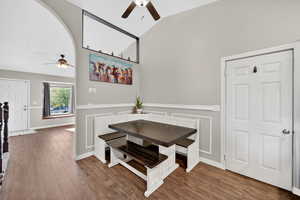 Dining room with a ceiling fan, wood finished floors, and lofted ceiling