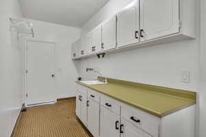 Laundry area featuring cabinet space and baseboards