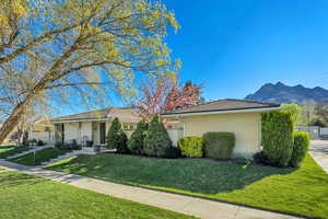 View of front of home featuring a front yard, brick siding, and a mountain view