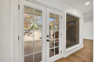 Doorway to outside with wood finished floors and recessed lighting