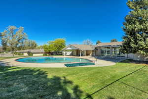 View of pool with patio surround and a sunroom