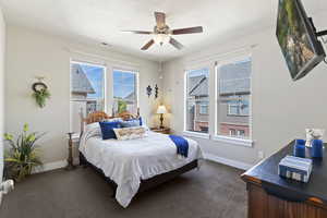 Bedroom featuring dark carpet, ceiling fan, and a textured ceiling