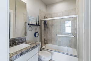 Full bath with vanity and shower / bath combination with glass door