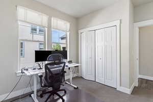 Home office featuring baseboards and dark colored carpet