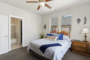 Bedroom with carpet, ensuite bath, and a ceiling fan