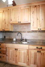Kitchen with light wood finish cabinetry and tasteful backsplash