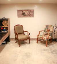 Sitting room featuring concrete flooring and baseboards