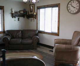 Living room with suspended lighting and wood finished floors