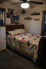 Bedroom with a ceiling fan and dark wood-style flooring