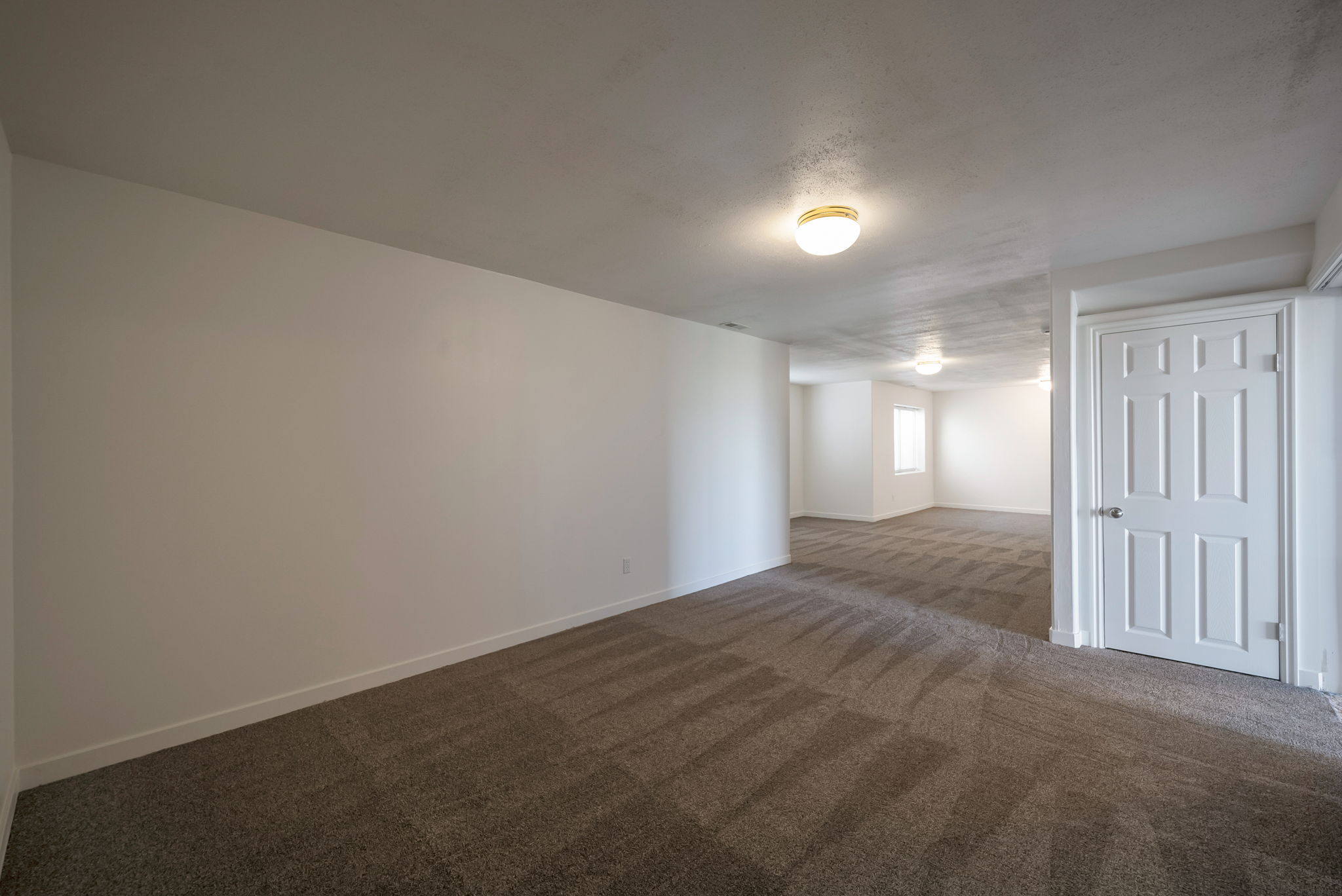 Empty room featuring dark colored carpet and baseboards