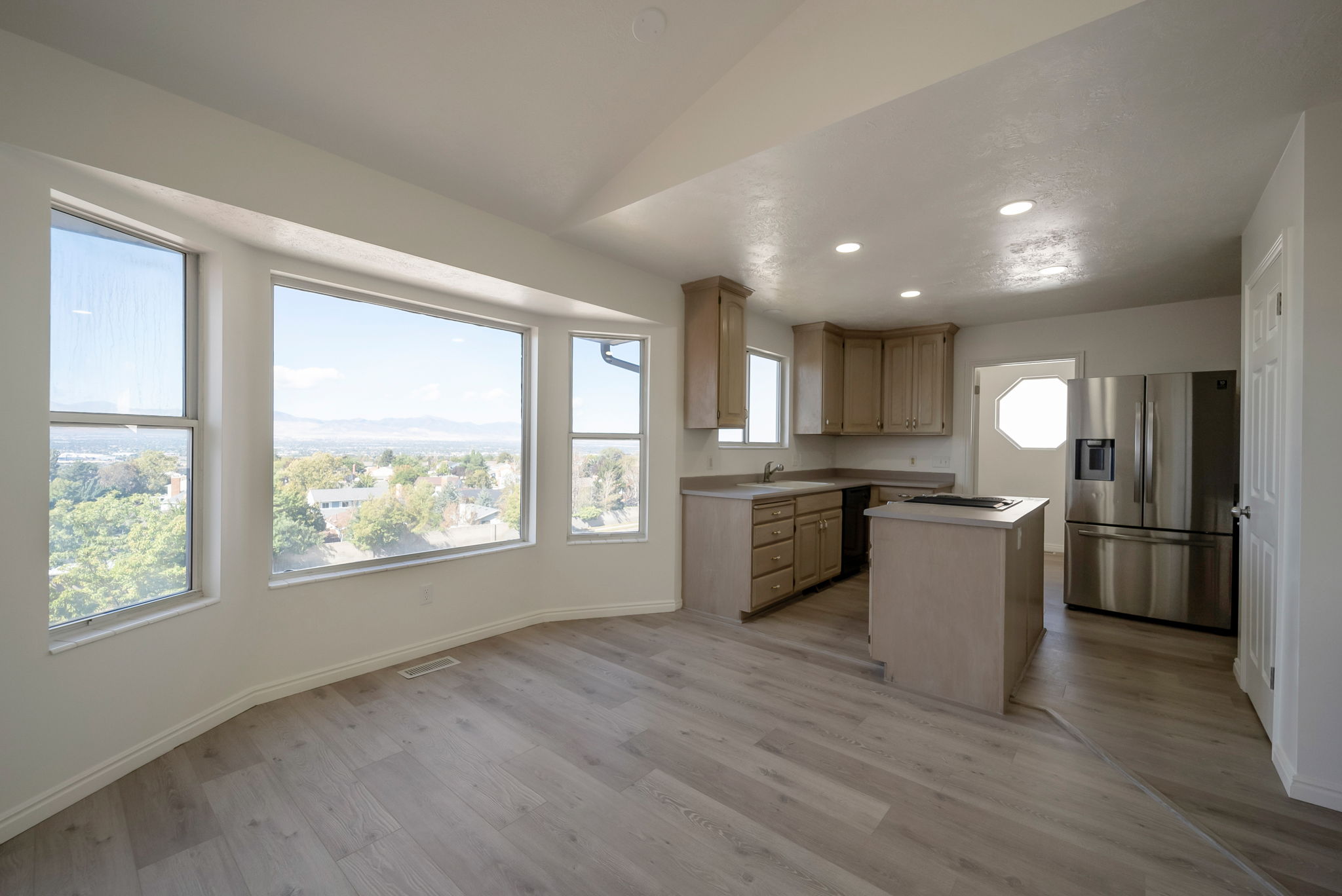 Kitchen featuring a center island, stainless steel appliances, recessed lighting, light wood finish cabinetry, and light wood-style floors