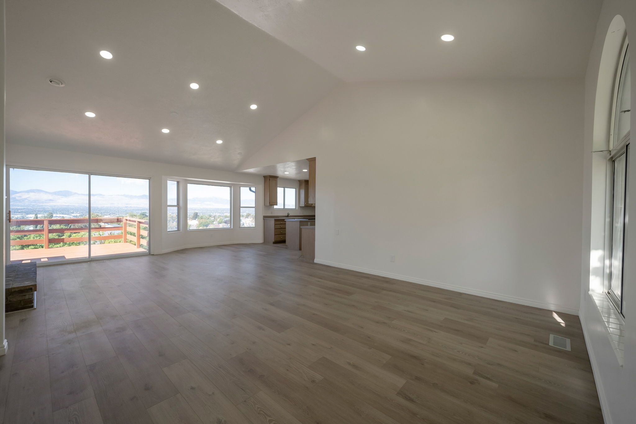 Unfurnished living room featuring lofted ceiling, recessed lighting, dark wood-style floors, and a mountain view