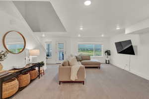 Living area with light carpet and recessed lighting