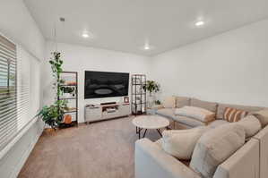 Living area featuring light carpet and recessed lighting