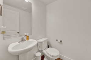 Half bathroom featuring toilet and baseboards