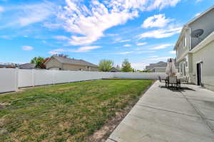 Fenced backyard featuring a patio area and a residential view