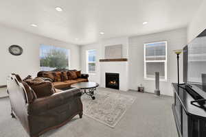 Living area featuring light colored carpet, a fireplace, and recessed lighting
