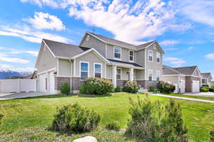 Traditional-style house with brick siding, an attached garage, driveway, a mountain view, and roof with shingles