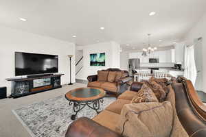 Living room with hanging lights and light carpet