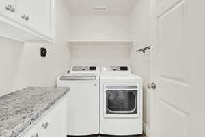 Laundry area featuring cabinet space and separate washer and dryer
