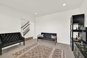 Sitting room with light carpet and recessed lighting