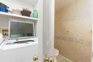 Laundry area with washer / dryer and wallpapered walls