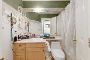 Full bath featuring wallpapered walls, vanity, and shower / tub combo with curtain