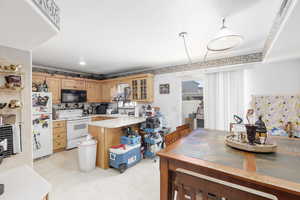 Kitchen with light flooring, light countertops, white appliances, a peninsula, and glass insert cabinets