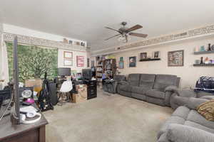 Living area with an office area, ceiling fan, and carpet flooring