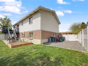 Rear view of property featuring a fenced backyard, brick siding, and a wooden deck