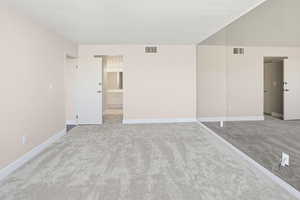 Unfurnished bedroom featuring light colored carpet and connected bathroom