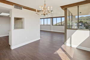 Unfurnished dining area with a chandelier, dark wood-style floors, and a mountain view