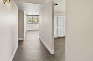 Hall with baseboards and dark wood-style flooring