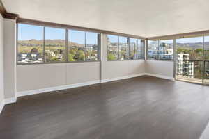 Unfurnished sunroom with a mountain view and wood finished floors