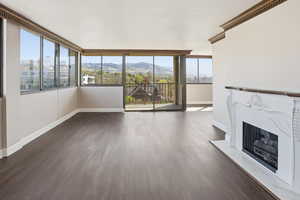 Unfurnished living room featuring a high end fireplace, dark wood finished floors, and a mountain view