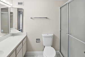 Full bath with a stall shower, vanity, and a textured wall