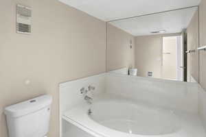 Full bath with toilet and a garden tub
