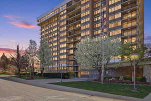 Property at dusk featuring a view of apartment building / complex