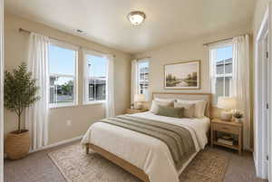 Carpeted bedroom featuring multiple windows with white trim and neutral wall paint