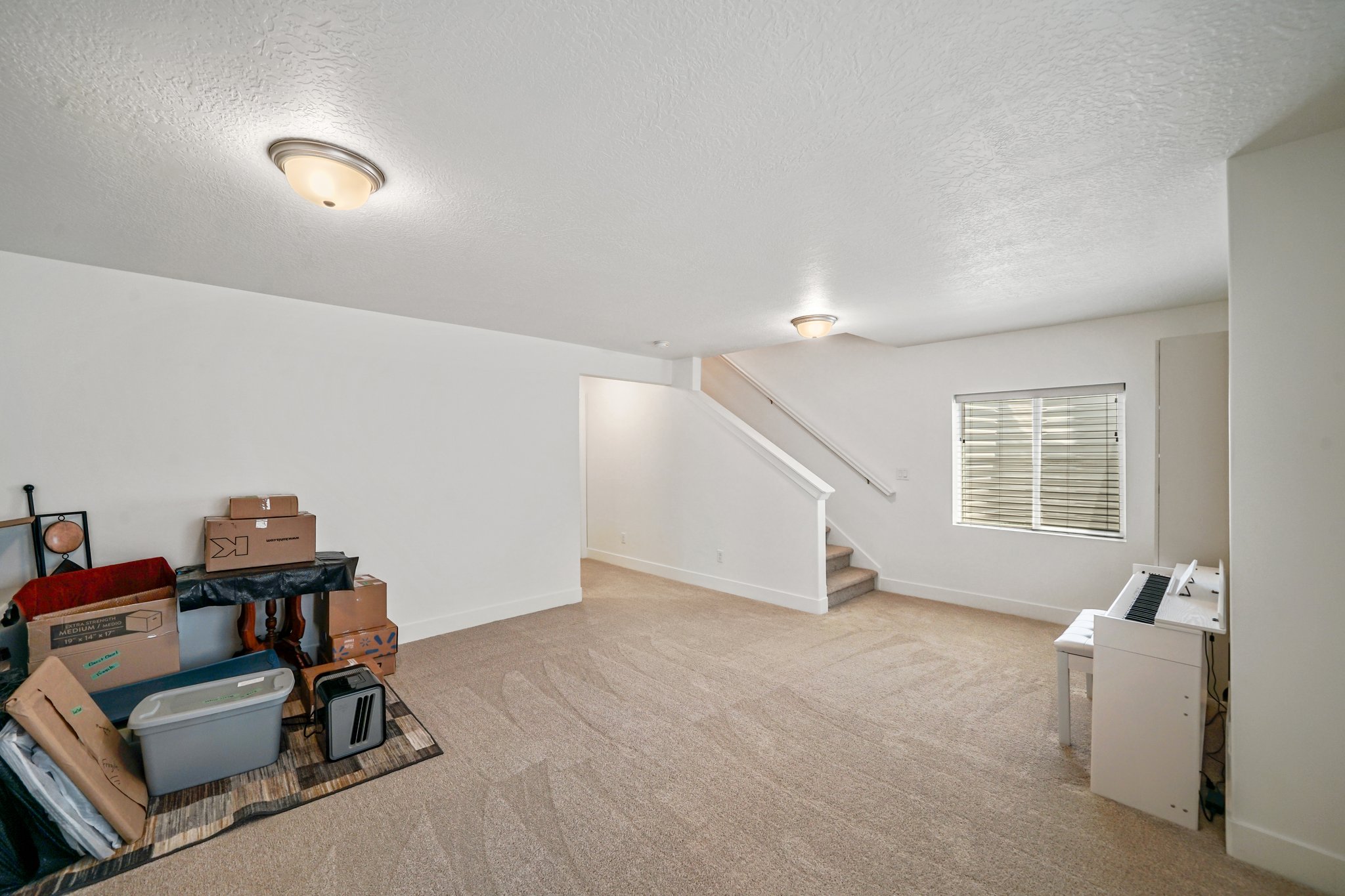 Game room featuring light carpet and a textured ceiling
