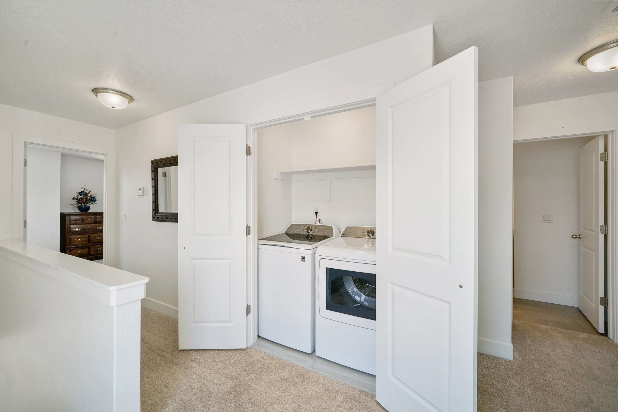 Laundry area with light carpet and independent washer and dryer