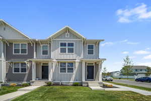 View of front of home featuring a front yard, board and batten siding, and a residential view