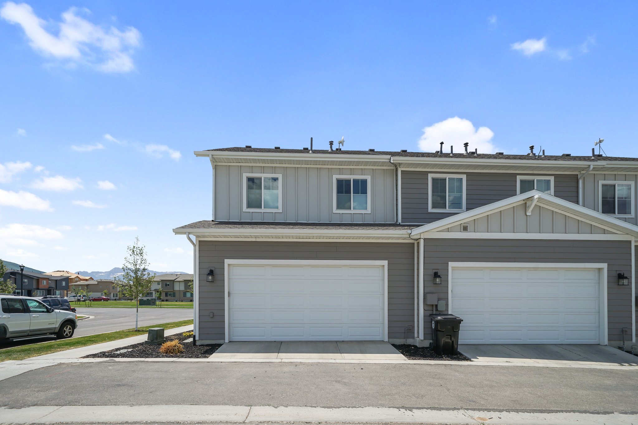 Traditional home with board and batten siding, a residential view, and an attached garage
