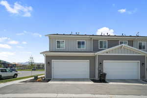 Traditional home with board and batten siding, a residential view, and an attached garage