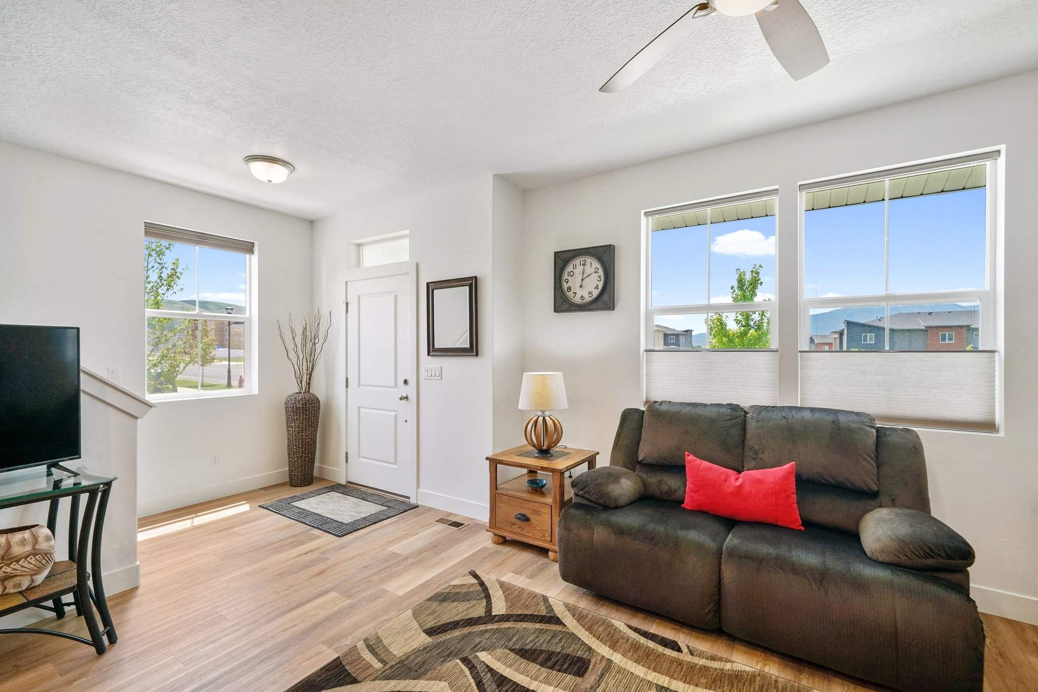 Living area featuring light wood finished floors, a ceiling fan, and a textured ceiling